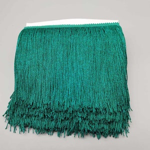May include: Teal green fringe trim with a soft, flowing texture. This trim is perfect for adding a touch of elegance to any project.