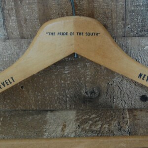 Puede incluir: Percha de madera con el texto "The Pride of the South" impreso en la parte superior y "The Roosevelt New Orleans" impreso en los lados.