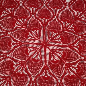 May include: A red crocheted table runner with a delicate, intricate pattern of overlapping circles and swirls.