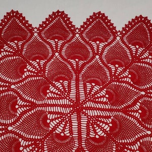 May include: Red crocheted doily with a delicate, intricate pattern of overlapping circles and swirls.
