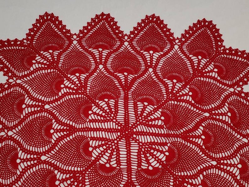 May include: Red crocheted doily with a delicate, intricate pattern of overlapping circles and swirls.