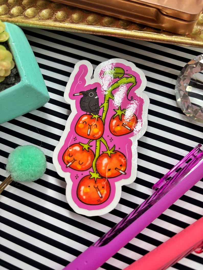 Puede incluir: Una pegatina con una ilustraci&oacute;n de dibujos animados de tomates en una vid, cada uno con un cigarrillo. Un p&aacute;jaro negro se posa en la vid. La pegatina tiene un borde rosa y est&aacute; sobre un fondo a rayas blancas y negras.