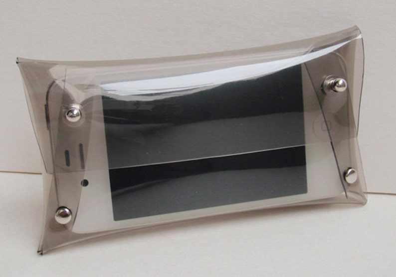 May include: A clear plastic pouch with silver metal snaps, designed to hold a smartphone or other small electronic device.