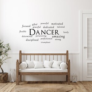May include: A white wall with a black word cloud that reads "DANCER" surrounded by words describing a dancer, such as "focused", "gifted", "powerful", "motivated", "graceful", "dedicated", "talented", "flexible", "determined", "persevering", "amazing", "disciplined", "perfectionist", "strong", "lovely", and "triumphant".