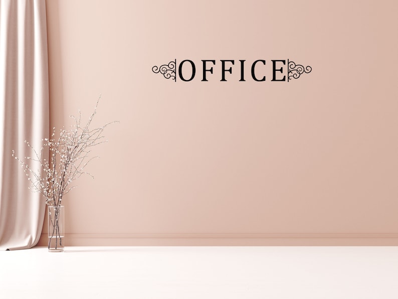Puede incluir: Una calcoman&iacute;a de pared en blanco y negro con la palabra "OFFICE" en una fuente decorativa. La calcoman&iacute;a se coloca en una pared rosa claro con un jarr&oacute;n blanco y una rama de flores blancas en primer plano.