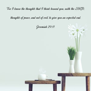 May include: A white wall with a quote from Jeremiah 29:11, "For I know the thoughts that I think toward you, saith the LORD, thoughts of peace, and not of evil, to give you an expected end."  Two wooden tables with white ceramic vases and a white ceramic mug on one of the tables.