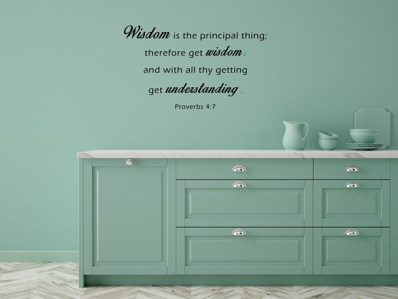 May include: A teal green kitchen with a white countertop and cabinets. The wall is painted a light teal green and features a black vinyl wall decal with the quote "Wisdom is the principal thing; therefore get wisdom. and with all thy getting get understanding. Proverbs 4:7".
