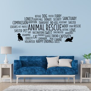 Peut inclure: Un canap&eacute; bleu avec des coussins blancs est plac&eacute; devant un mur bleu clair avec un nuage de mots noir sur le th&egrave;me du sauvetage des animaux. Le nuage de mots comprend des mots comme "refuge", "chien", "chat", "abri", "amour", "heureux d&eacute;nouement" et "b&eacute;n&eacute;vole".