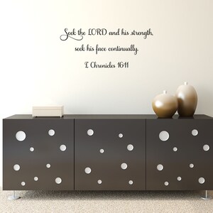 May include: A black and white wall decal with the quote "Seek the LORD and his strength, seek his face continually. I Chronicles 16-11". The decal is displayed on a white wall above a black dresser with white polka dots.