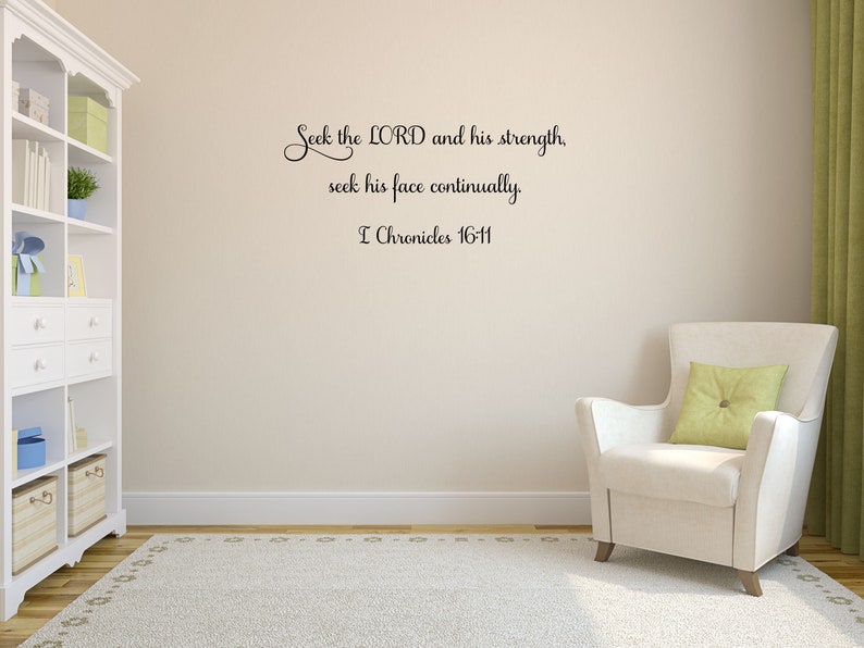 May include: A white wall with a black vinyl wall decal featuring a bible verse: "Seek the LORD and his strength, seek his face continually. I Chronicles 16-11". The wall is in a room with a white bookshelf and a white armchair with a green pillow.