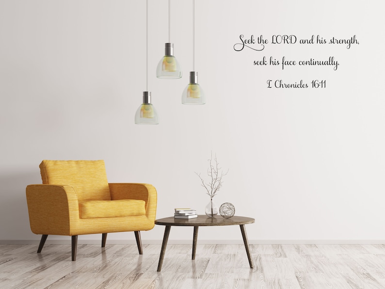 May include: A living room interior with a yellow armchair, a coffee table, and a wall decal with the Bible verse "Seek the LORD and his strength, seek his face continually. I Chronicles 16-11."