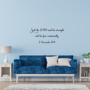 May include: A blue couch with white throw pillows sits in front of a light blue wall with a black and white wall decal that reads "Seek the LORD and his strength, seek his face continually. I Chronicles 16:11".