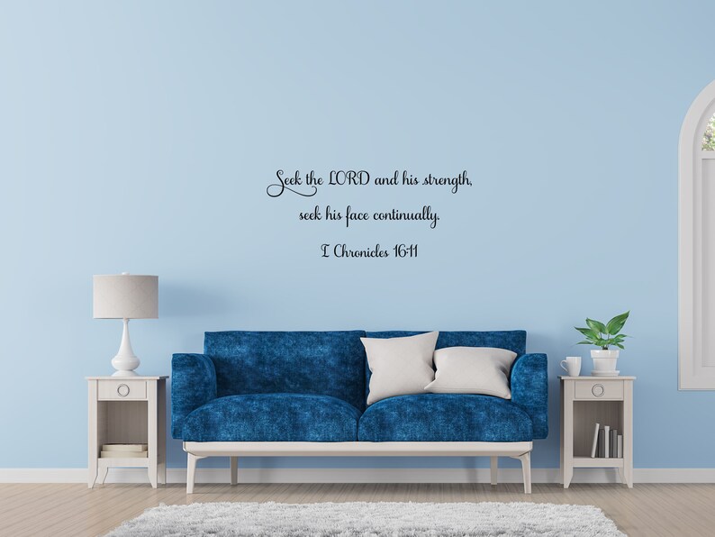 May include: A blue couch with white throw pillows sits in front of a light blue wall with a black and white wall decal that reads "Seek the LORD and his strength, seek his face continually. I Chronicles 16:11".