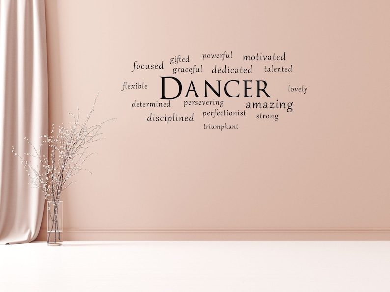 May include: A pink wall with black text that reads "gifted powerful motivated focused graceful dedicated talented flexible DANCER lovely determined persevering amazing disciplined perfectionist strong triumphant"