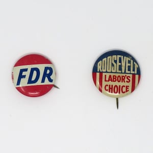 May include: Two round, pin-back buttons with political campaign slogans. The first button is red, white, and blue with the text "FDR" in blue. The second button is blue, white, and red with the text "ROOSEVELT LABOR'S CHOICE".
