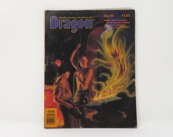 Può includere: Dragon Magazine numero 123, un aiuto mensile per giochi di ruolo di avventura. La copertina presenta un'illustrazione fantasy oscura di due persone che lavorano a una fucina con uno spirito ardente e incandescente.