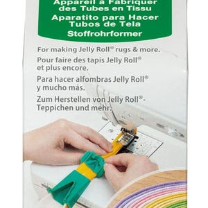May include: A green and yellow plastic tool for making fabric tubes. The tool is shown being used on a sewing machine to create a colorful fabric tube. The packaging includes the text "Fabric Tube Maker" and "Jelly Roll® rugs & more."