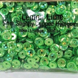May include: A bag of 5mm green holographic sequins, labeled "Lemon Lime Slightly Cupped Hologram h5scLL appx 1000 ct".