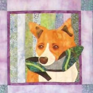 May include: A colorful patchwork quilt block featuring a dog's face with a green and brown scarf. The dog has brown ears, a white muzzle, and orange fur.