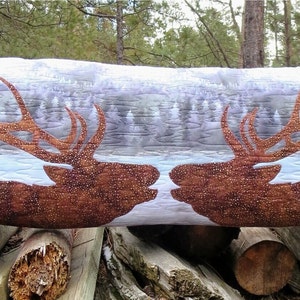 May include: A long, rectangular pillow with a quilted design featuring two brown elk heads facing each other. The background is a light blue and white pattern that resembles a snowy forest.