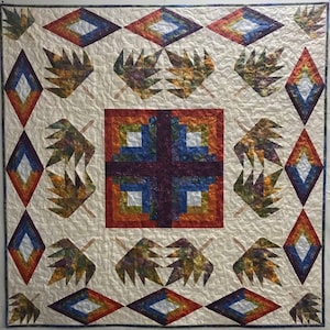 May include: A quilt with a central square design featuring a cross pattern in shades of red, orange, blue, and purple. The square is surrounded by a border of diamond shapes in shades of orange, red, blue, and white. The background is a cream color and the quilt is decorated with leaf-shaped patterns in shades of brown, green, and orange.