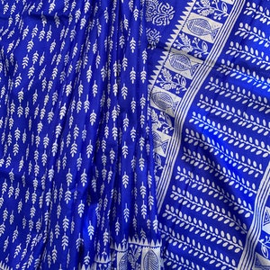 May include: A blue and white cotton saree with a traditional block print design. The saree features a repeating pattern of leaves and fish.
