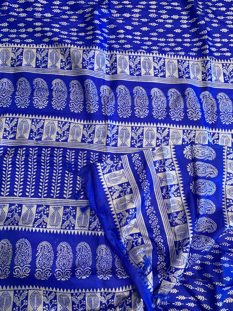 May include: A blue fabric with a white paisley pattern. The fabric has a repeating pattern of paisley shapes, leaves, and fish.