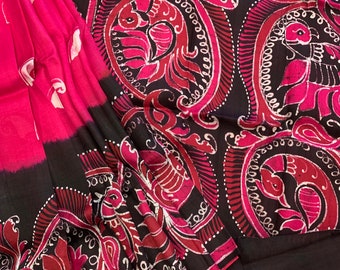 May include: A pink and black silk saree with a traditional paisley pattern. The saree is made of a soft, flowing fabric and features intricate details.