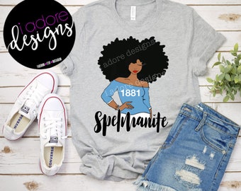Könnte beinhalten: Graues T-Shirt mit einer schwarzen und blauen Illustration einer Frau mit Afro, die ein blaues Shirt mit dem Text "1881" und dem Text "Spelmamite" trägt.