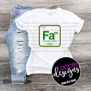 May include: White t-shirt featuring a green and gold graphic of a periodic table element. The element is labelled "Fam" with the text "Florida A&M 1887". The graphic is surrounded by the text "I adore designs" repeated multiple times.