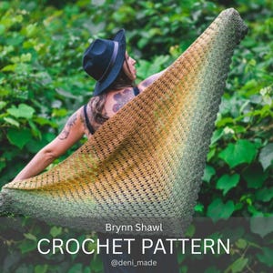 May include: A crocheted shawl in shades of green, yellow, and brown is displayed against a backdrop of green foliage. The shawl is labeled "Brynne Shawl" and "CROCHET PATTERN". The gradient color scheme adds visual interest to the handmade item.