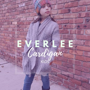 May include: A gray crocheted cardigan with a long, open front. The cardigan is worn by a child wearing a colorful crocheted hat and blue jeans. The text "EVERLEE Cardigan KIDS" is visible on the image.