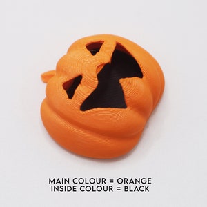 May include: Orange plastic pumpkin with a black face carved into it.