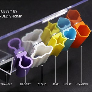May include: A set of colorful plastic tubes shaped like a triangle, droplet, cloud, star, heart, and hexagon. The tubes are arranged in a row from left to right. The text "SPOOD TUBES&trade; BY THE BEARDED SHRIMP" is visible at the top of the image.