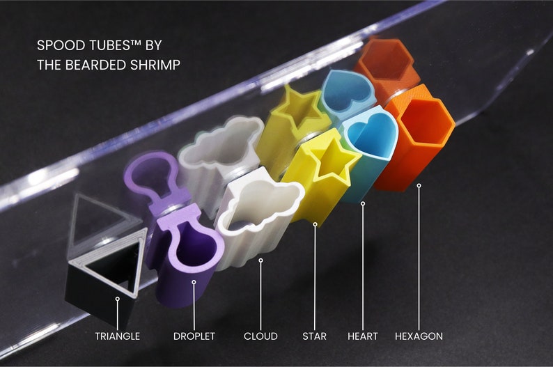 May include: A set of colorful plastic tubes shaped like a triangle, droplet, cloud, star, heart, and hexagon. The tubes are arranged in a row from left to right. The text "SPOOD TUBES&trade; BY THE BEARDED SHRIMP" is visible at the top of the image.