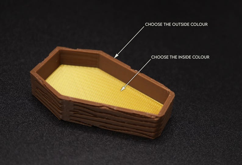 Op de afbeelding: Een klein houten doosje in de vorm van een kist met een getextureerd houtnerfdesign. De binnenkant van het doosje is effen geel. Kies de buiten- en binnenkleuren.