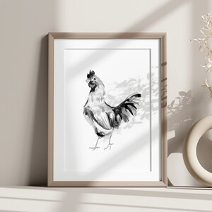 Puede incluir: Una ilustración enmarcada en tinta negra y blanca de un gallo en un estilo simple y moderno. El gallo está de pie sobre un fondo blanco con una sombra sutil.
