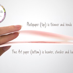 Op de afbeelding: Een hand houdt twee vellen papier vast, een bovenop de ander. Het bovenste vel is fotopapier, dat dunner is en gemakkelijk buigt. Het onderste vel is fine art papier, dat zwaarder, steviger is en nauwelijks buigt. De tekst "Photopaper (top) is thinner and bends easily." en "Fine Art paper (bottom) is heavier, sturdier and hardly bends." staat onder de vellen.