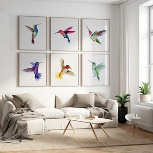 Puede incluir: Un conjunto de seis pinturas de acuarela enmarcadas de colibr&iacute;es en varios colores, incluyendo azul, verde, rojo y amarillo. Las pinturas est&aacute;n dispuestas en un patr&oacute;n de cuadr&iacute;cula en una pared blanca.