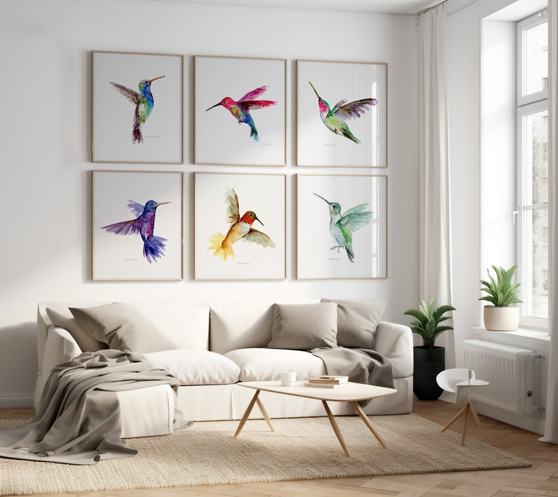 Puede incluir: Un conjunto de seis pinturas de acuarela enmarcadas de colibr&iacute;es en varios colores, incluyendo azul, verde, rojo y amarillo. Las pinturas est&aacute;n dispuestas en un patr&oacute;n de cuadr&iacute;cula en una pared blanca.