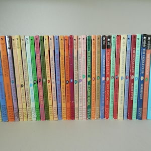 May include: A collection of The Saddle Club books, featuring colorful spines with titles like "Horse Crazy" and "Horse Magic." The books are arranged on a shelf, creating a visually appealing display for young readers.