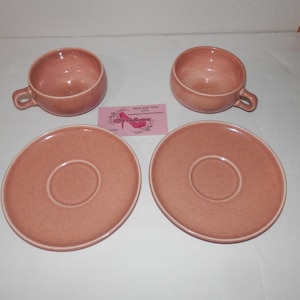 Peut inclure: Service à thé vintage en quatre pièces de couleur rose clair moucheté. L'ensemble comprend deux tasses à thé avec anses et deux soucoupes assorties. Les tasses et les soucoupes ont un design simple et classique.