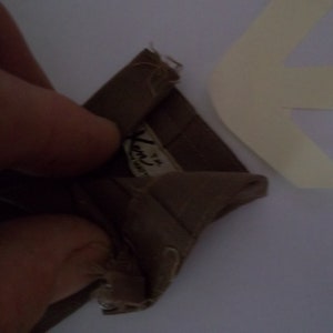 May include: A brown fabric swatch with a white label that reads "Ken's Fabrics" and a small number "4" in the corner.