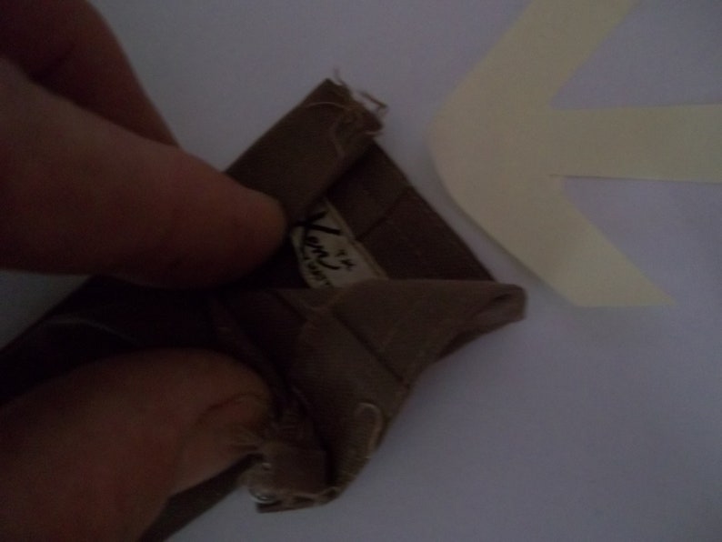 May include: A brown fabric swatch with a white label that reads "Ken's Fabrics" and a small number "4" in the corner.