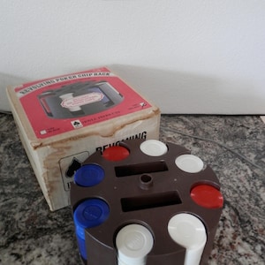 May include: A brown revolving poker chip rack with white, red, and blue poker chips. The rack has a slot for cards and the box says "Revolving Poker Chip Rack".
