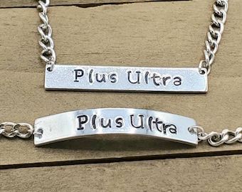 May include: A silver necklace and bracelet set with a silver chain and a rectangular tag that reads "Plus Ultra".