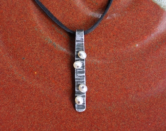 Iron and Pearl Barnacle Pendent: Forged Iron Textured Bar with 4 white freshwater pearls on Leather with black finish