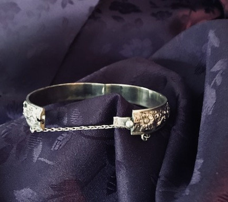 This bangle is very detailed and exquisite. Childs vintage embossed bangle with safety chain rare find