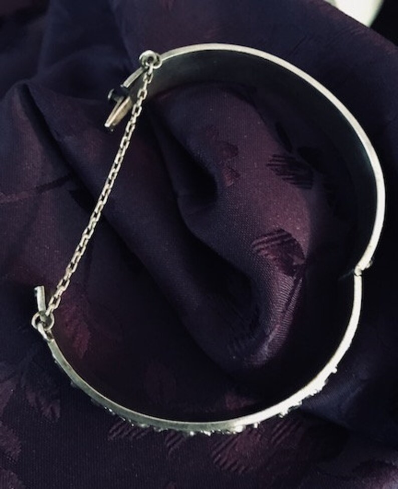 This bangle is very detailed and exquisite. Childs vintage embossed bangle with safety chain rare find