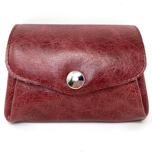 May include: A burgundy leather coin purse with a silver snap closure.